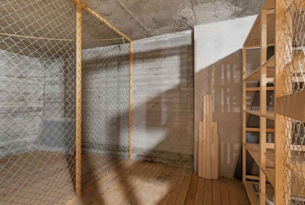 An empty basement with concrete foundation walls and empty wooden storage shelves.